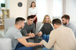 © Africa Studio - Young people holding hands together during group therapy, indoors