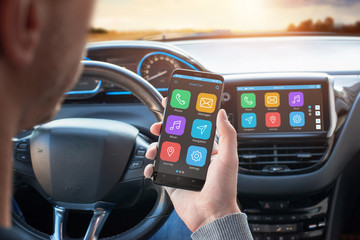 Driver uses a mobile phone with smart driving assistance apps. The app is connected to a car computer and is displayed on the board display.