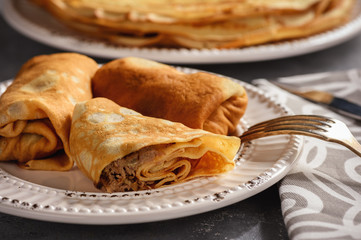 Wall Mural - Pancakes stuffed with meat, on dark background.