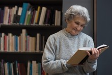 Senior Woman Reading A Book In Library