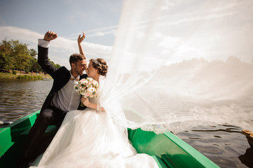 Wall Mural - Happy and smiling bride with bridegroom in the boat