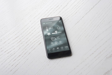 Poster - Modern smart phone with home control app on white wooden surface.