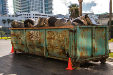 Rusty Dumpster In Parking Lot