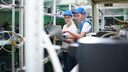 Man and woman on the farm for the extraction of crypto currencies. Bitcoin mining