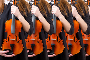 girls with violins stand in a row