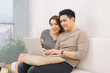 © makistock - Happy asian couple in love surfing on laptop at home