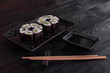 Flower from rolls maki sushi on a black stone plate. Fresh made Sushi set with cheese and cucumber. Traditional Japanese cuisine.
