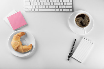 Fototapete - Tasty crescent roll with cup of coffee and computer keyboard on white background