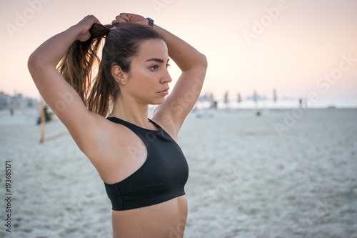 Beautiful Sporty Girl Tying Hair Before Her Workout At Beach