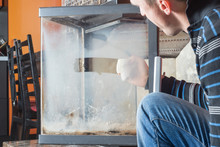 Man Wipes The Dirty Glass Of Fireplace