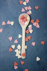 White spoon whit decorative elements. Creative layout of hearts. Selective focus. Food concept. 