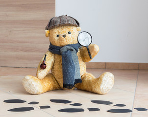 Wall Mural - Sherlock Holmes teddy bear detective investigates - black footprints on the floor