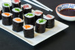 A selection of sushi rolls with salmon, tuna and cucubmer with soy sauce dip.