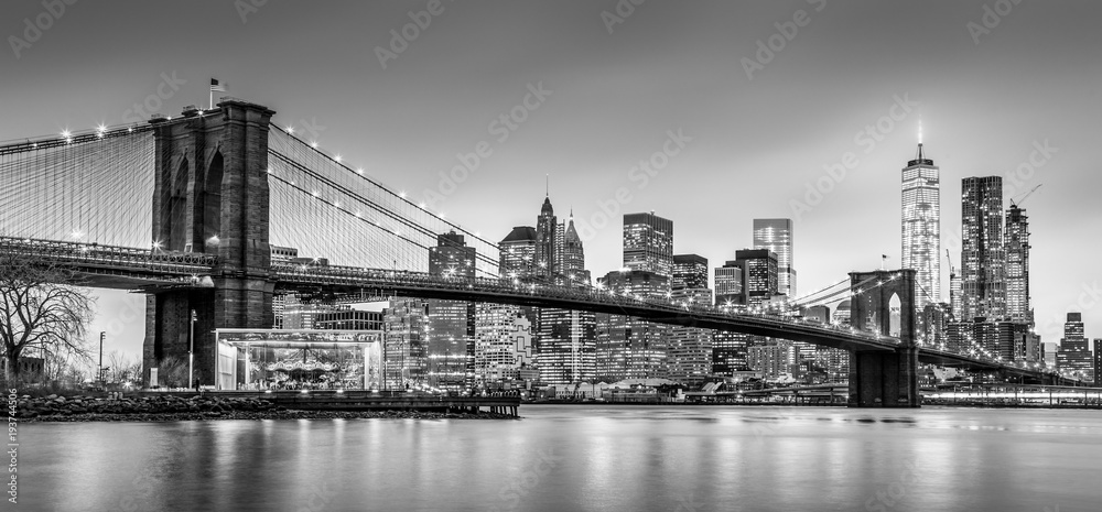Brooklyn bridge and New York City Manhattan downtown skyline at dusk with skyscrapers illuminated over East River panorama. Panoramic composition. - obrazy, fototapety, plakaty 