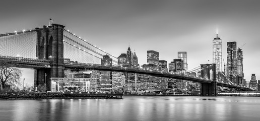 Fototapete - Brooklyn bridge and New York City Manhattan downtown skyline at dusk with skyscrapers illuminated over East River panorama. Panoramic composition.