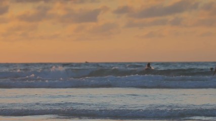 Wall Mural - sunset sea, tropical beach, two girls running out into the water with joy making splashes in slowmot