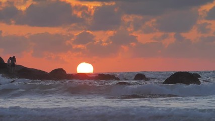 Wall Mural - beautiful ocean sunset with last light of the sun in sea waves crashing against rocks in slowmotion