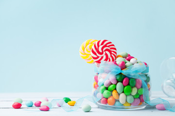 jar staffed sweet colorful candy against turquoise background. gifts for birthday party.