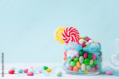 Fotomural Jar staffed sweet colorful candy against turquoise background