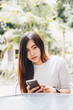 © themorningglory - Beautiful asian business women siting in cafe park use phone