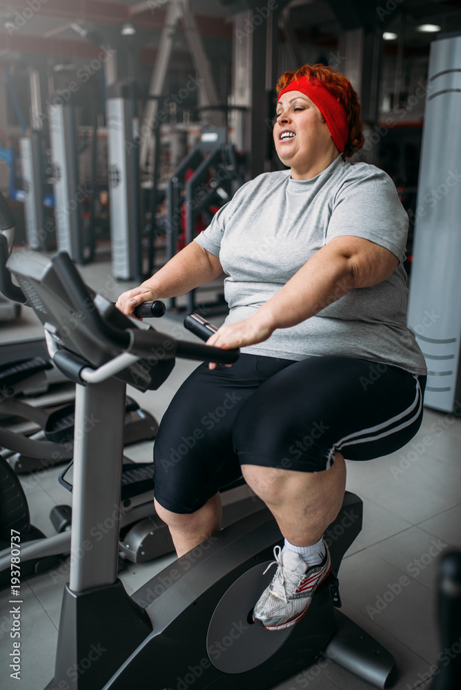 Fat woman training on exercise bike in gym Stock Photo Adobe Stock