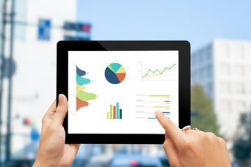 Poster - close-up hand using modern tablet showed charts and graph on screen