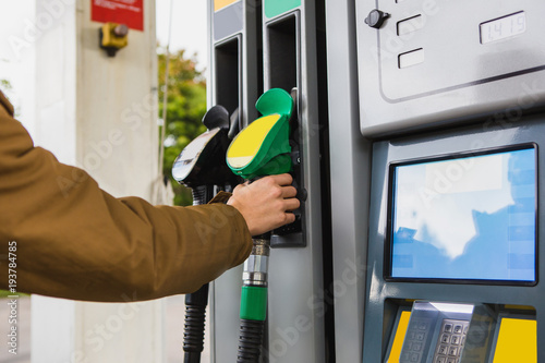 Fotografie, Obraz Self-service gas station. A man takes a refueling nozzle