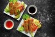 Chinese vegetable spring rolls garnished with fresh salad, lime wedges, sweet chilli sauce and soy sauce