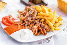 Greek Gyros On A Plate With French Fries And Vegetables