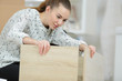 © auremar - young woman assembling the parts of the furniture
