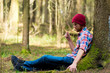 © kosmos111 - portrait of a man in a cap and plaid shirt sitting near a tree in the forest