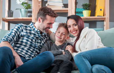 Portrait of happy family sitting on sofa at home