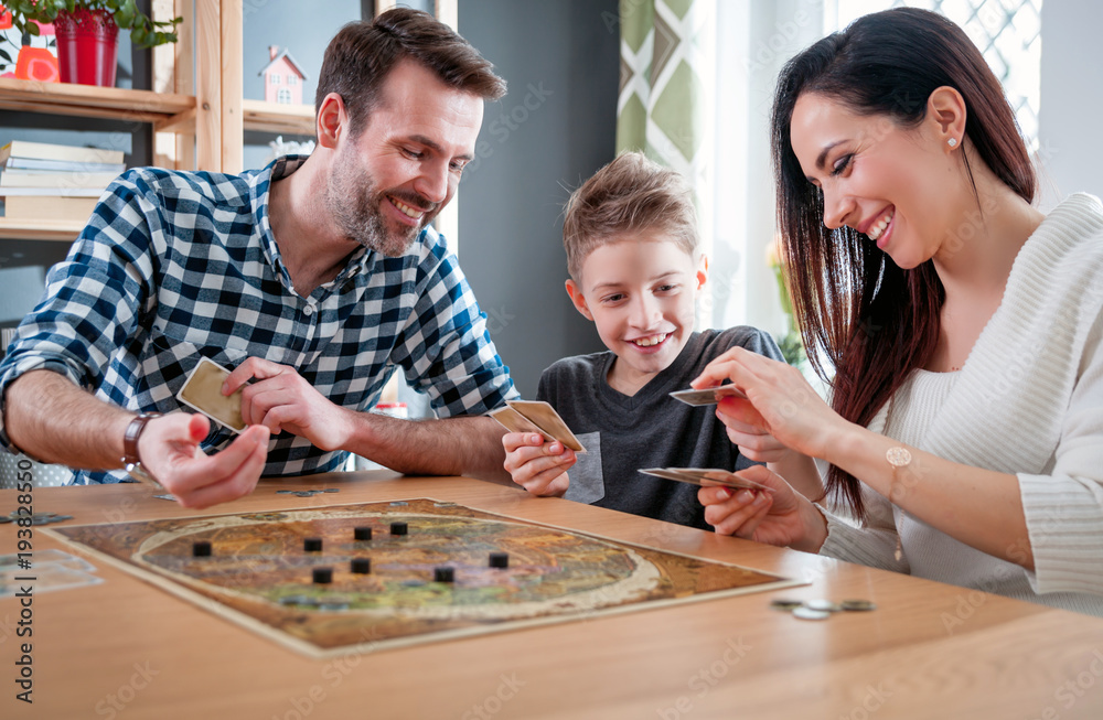 Happy family playing board game at home - obrazy, fototapety, plakaty 