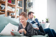 © leszekglasner - Father and son using digital devices at home, laptop and tablet