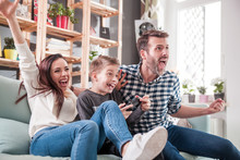 Excited family playing video game on the console at home