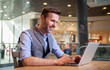 © leszekglasner - Confident businessman using laptop in modern interior