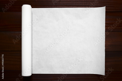 Cuadros en Lienzo Eine Rolle Backpapier ausgerollt auf dunklem Holz, fotografiert mit natürlichem