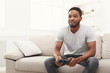© Prostock-studio - Happy young african-american man at home playing video games