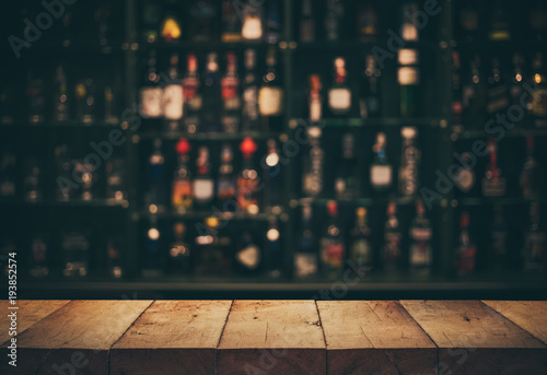 Fotografía Empty the top of wooden table with blurred counter bar and bottles Background