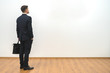 © realstock1 - The man with a case standing on the white wall background