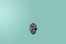 Vintage Door Lock With Key. On A Pastel Blue, Turquoise Background, There Is A View Of The Front Of The Old And Antique Key Lock. The Key Inserted Into The Center. Minimalism.