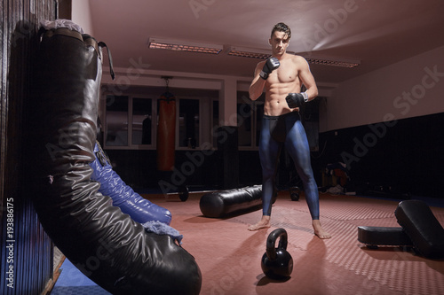 Fotomural one boxer posing, indoors, boxing bag, fitness boxing equipment, flooring