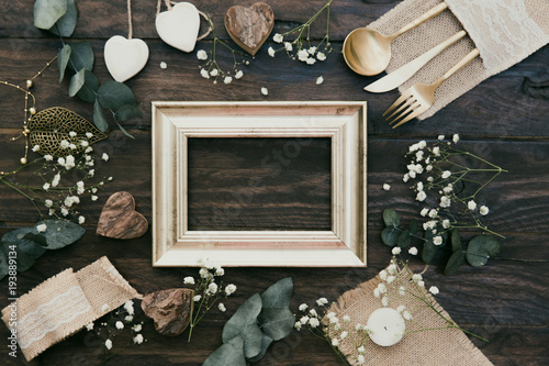 Fotografía Details of a rustic wedding with gold frame over wooden background