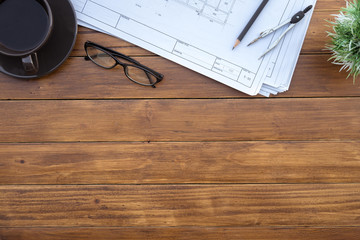 Poster - Flat lay of top view desk work table architect with drawing home plan building and stationary on antique brown wood table in home office includes copyspace for add text or graphic