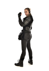 full length portrait of female soldier wearing black tactical armour facing away from camera, isolat