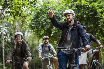 Poster - Group of friends ride mountain bike in the forest together