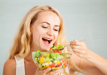 Young woman preparing vegetable salad