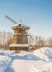 Rural winter landscape with an old wooden windmill