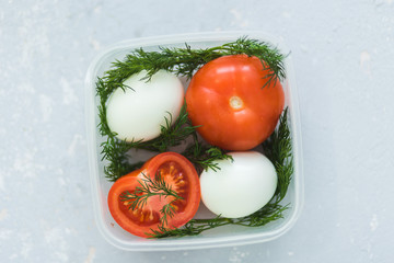 Wall Mural - Ripe tomatoes and eggs in container on grey background close up. Healthy diet.