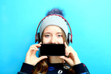 Fototapeta Panele - girl on headphones with a smartphone